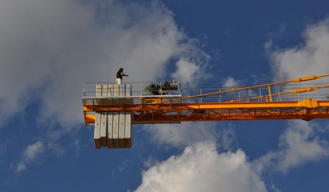 Maaş alamayınca vincin tepesine çıktı