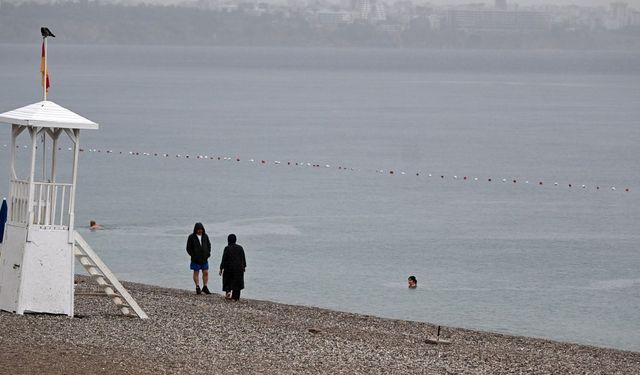 Antalya’da yağış deniz keyfine engel olmadı: Konyaaltı’nda denize girdiler